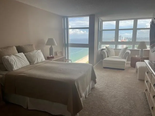 a bedroom with a bed and a large window