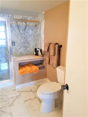 a bathroom with a toilet and a shower