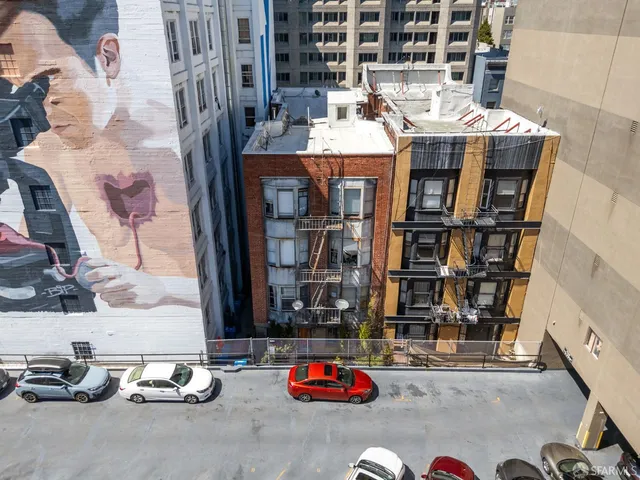 walk in front of building with cars parked