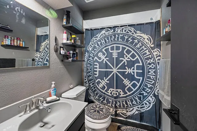 a bathroom with a sink mirror vanity and toilet