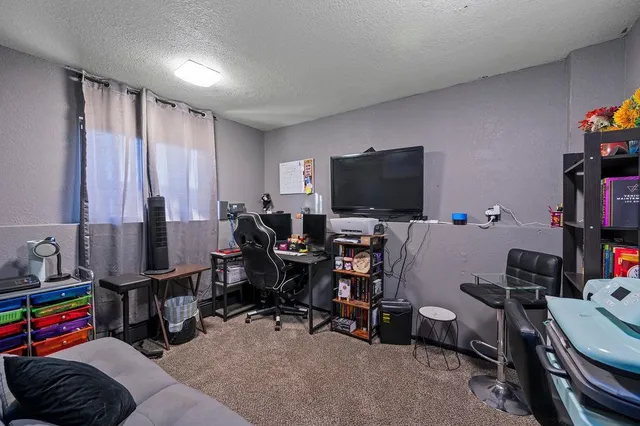 a view of a workspace with furniture and a window