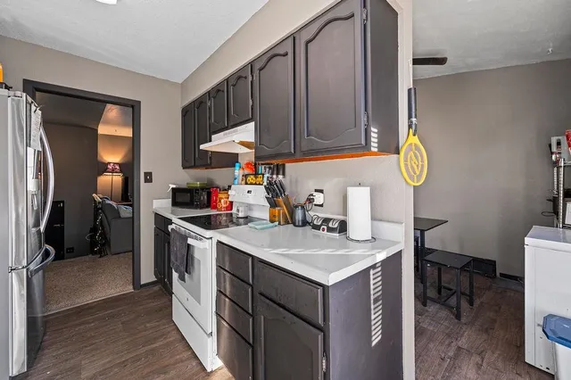 a kitchen with a sink cabinets and wooden floor