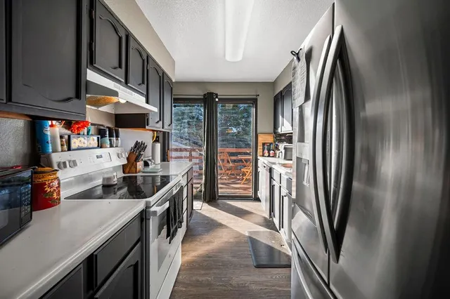 a kitchen with stainless steel appliances granite countertop a refrigerator and a sink