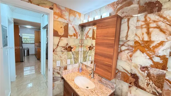 a bathroom with a granite countertop shower and a sink