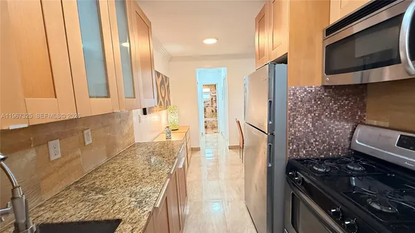 a kitchen with stainless steel appliances granite countertop a refrigerator and a stove