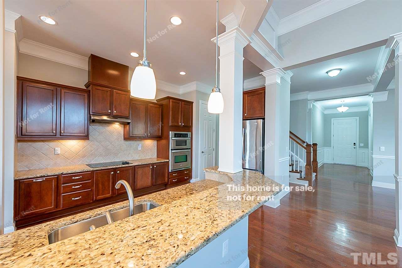 1225 Chapanoke Road Raleigh, NC 27603 - Photo 8 of 27 a kitchen with stainless steel appliances granite countertop wooden cabinets and granite counter tops