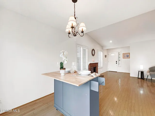 a view of kitchen center island wooden floor and living room view