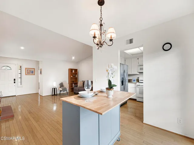 a living room with kitchen island furniture and a chandelier