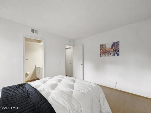 a bedroom with a bed and a painting on the wall