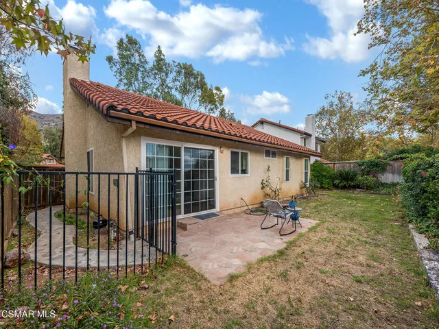 a backyard of a house with table and chairs