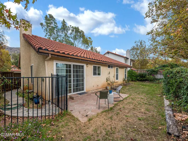 a view of a house with backyard and sitting area