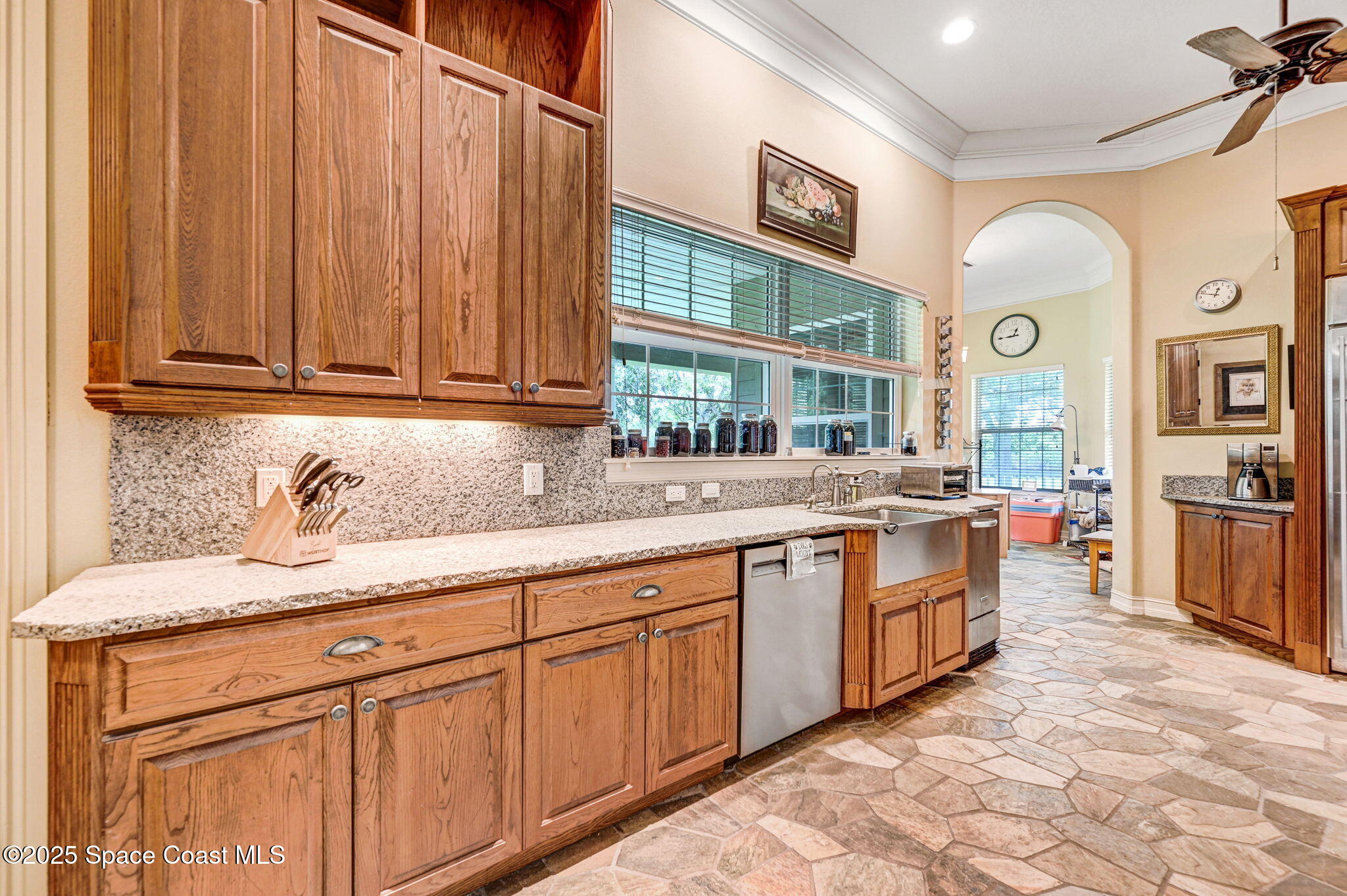 4495 Sand Point Road Grant, FL 32949 - Photo 38 of 87 a large kitchen with granite countertop a sink and dishwasher a stove with wooden cabinets