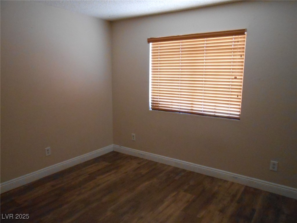 4720 Krissylouise Way, Unit B Las Vegas, NV 89121 - Photo 7 of 14 Empty room with wood finished floors and a textured ceiling