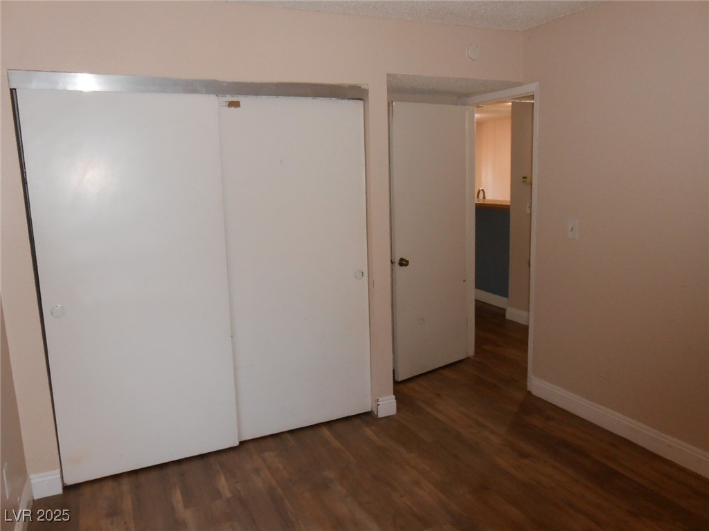 4720 Krissylouise Way, Unit B Las Vegas, NV 89121 - Photo 10 of 14 Unfurnished bedroom featuring wood finished floors, a closet, and a textured ceiling