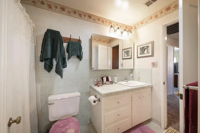 a bathroom with a toilet sink and mirror