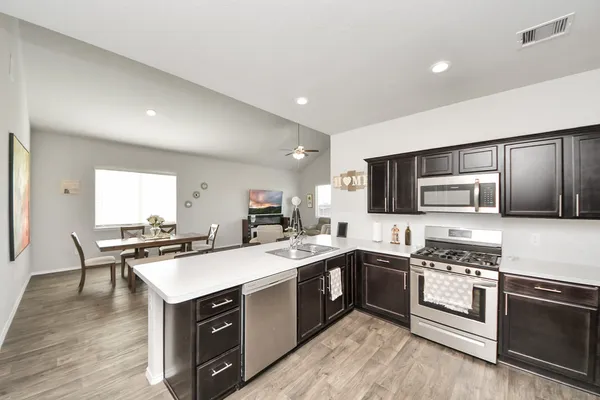 a kitchen with stainless steel appliances a stove a sink and a microwave