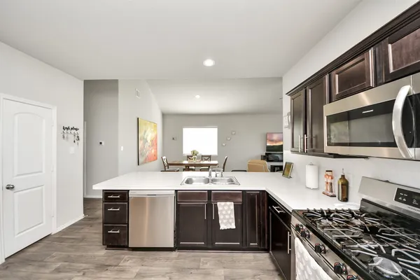 a kitchen with stainless steel appliances a sink a stove a refrigerator and cabinets