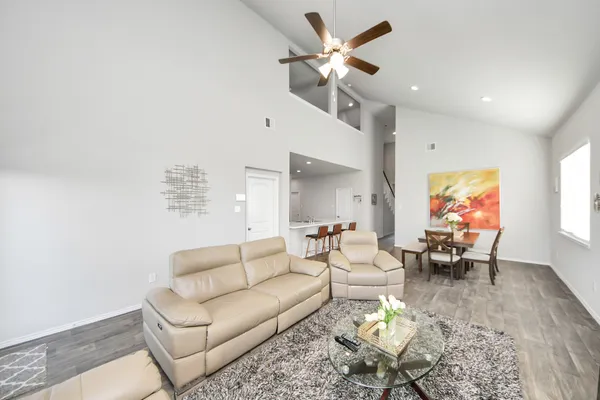 a living room with furniture a ceiling fan and a wooden floor