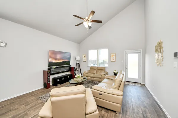 a living room with furniture a flat screen tv and a window