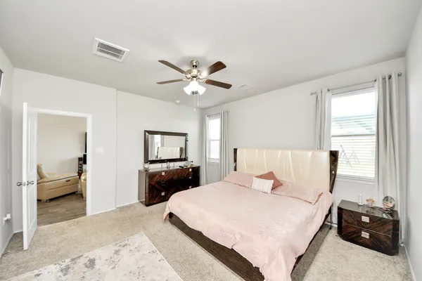 a bedroom with a large bed and a chandelier