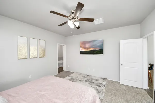 a bedroom with a bed and dresser with wooden floor