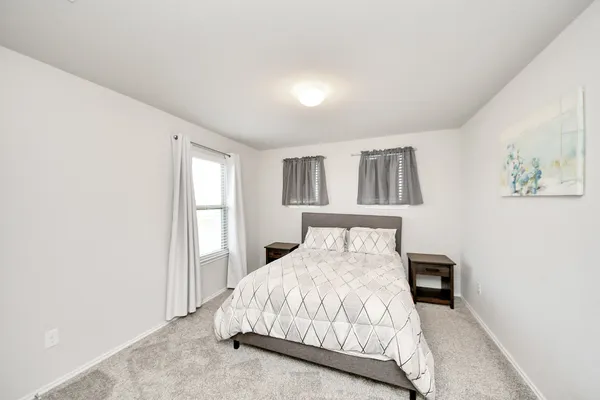 a bedroom with a bed and painting on the wall