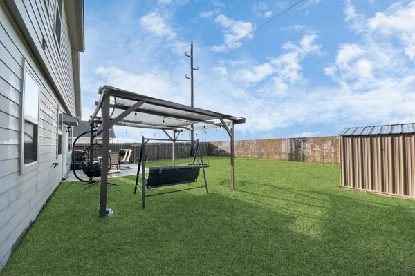 a view of a chairs and table in patio with a yard