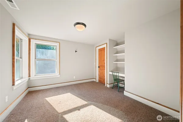 an empty room with windows and closet