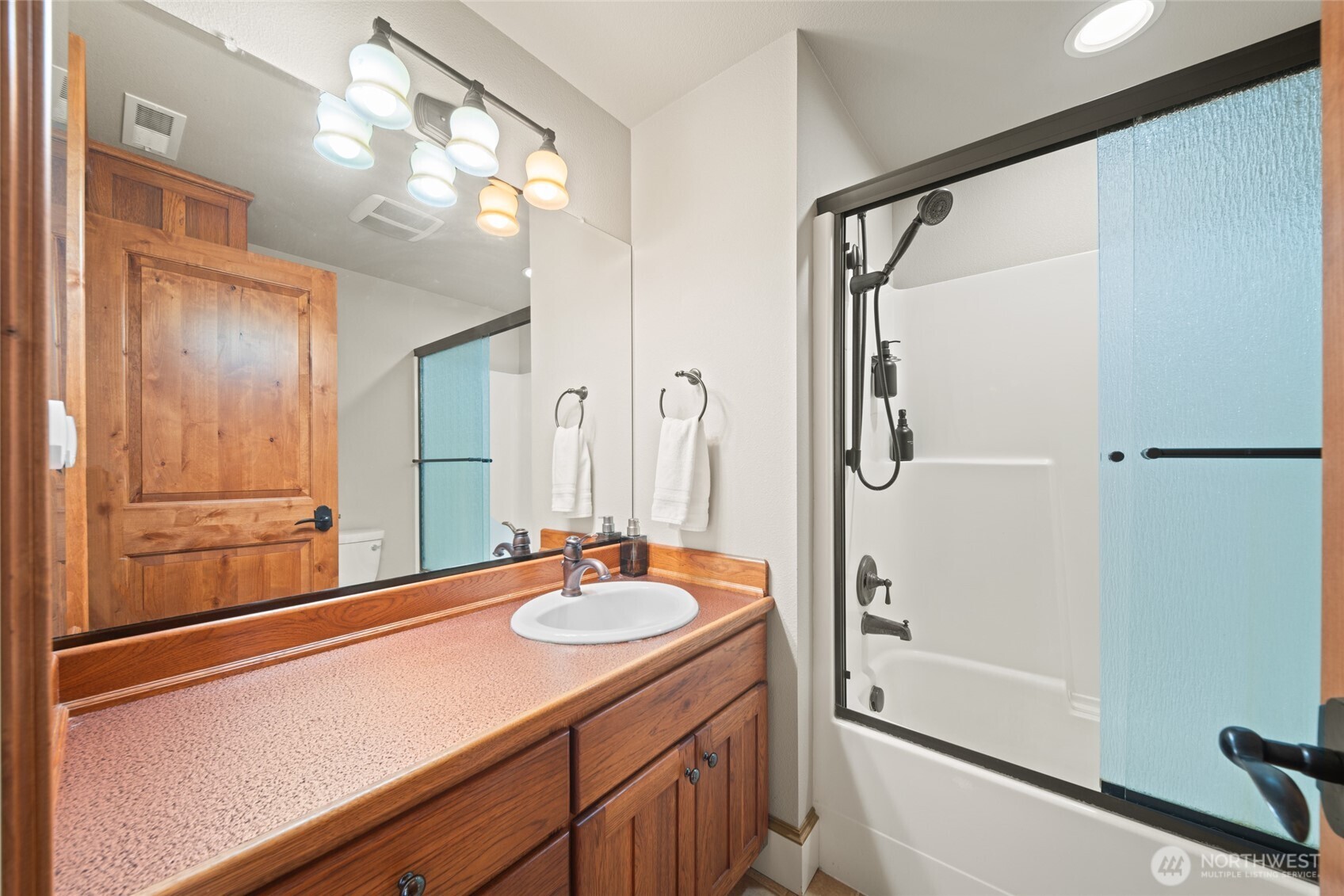 340 Arrowhead Road Ariel, WA 98603 - Photo 18 of 40 a bathroom with a shower sink vanity and mirror
