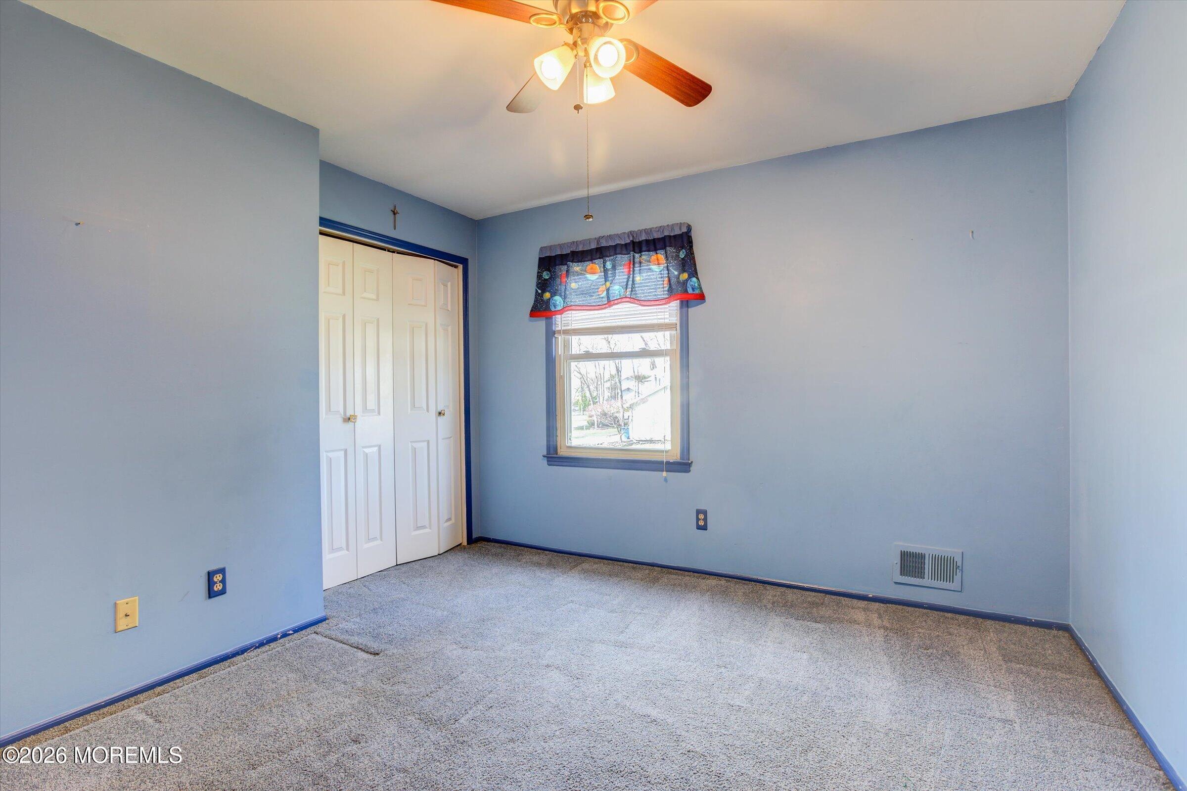 18 Warne Road Matawan, NJ 07747 - Photo 19 of 28 an empty room with chandelier fan and windows
