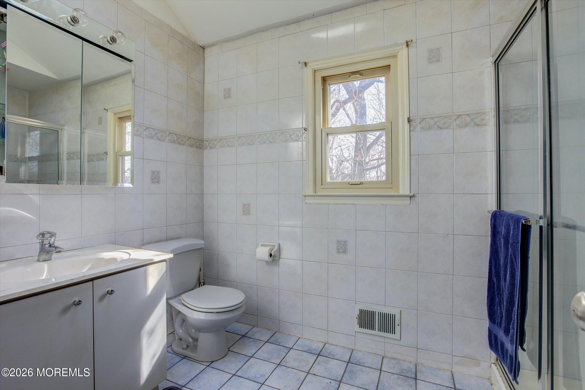 18 Warne Road Matawan, NJ 07747 - Photo 22 of 28 a bathroom with a toilet a sink a shower and a mirror