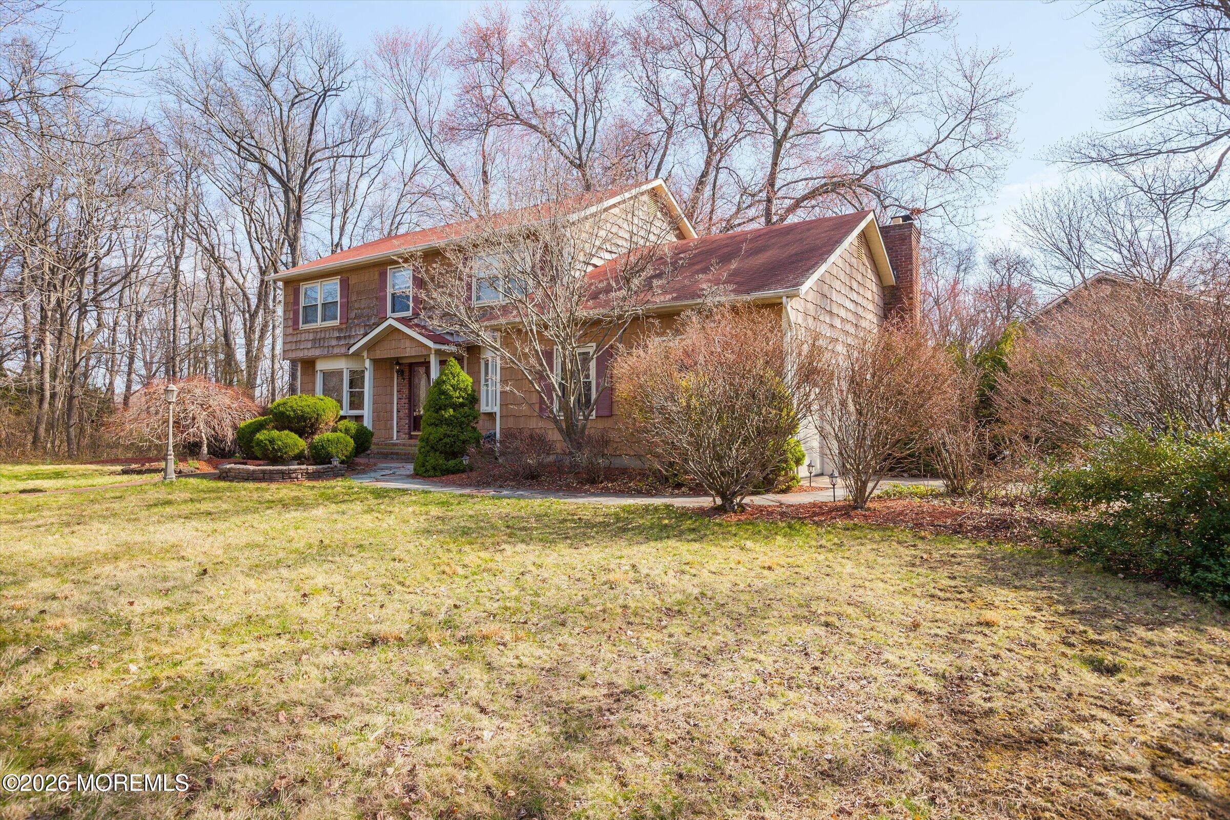 18 Warne Road Matawan, NJ 07747 - Photo 3 of 28 a backyard of a house with large trees and outdoor seating