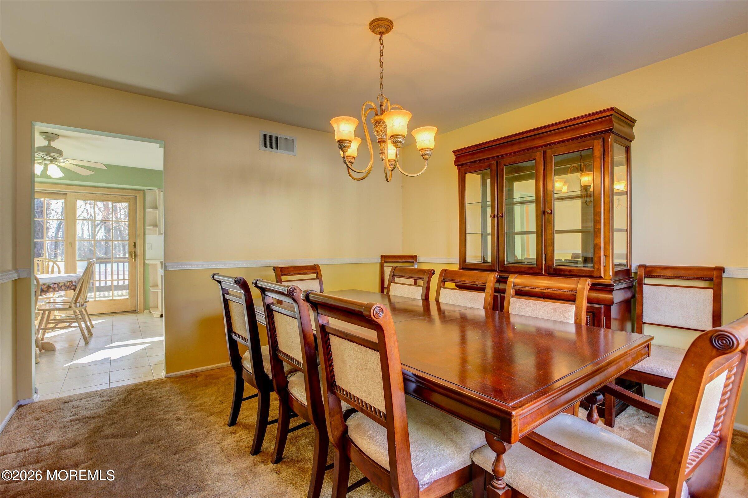 18 Warne Road Matawan, NJ 07747 - Photo 9 of 28 a dining room with furniture a chandelier and wooden floor