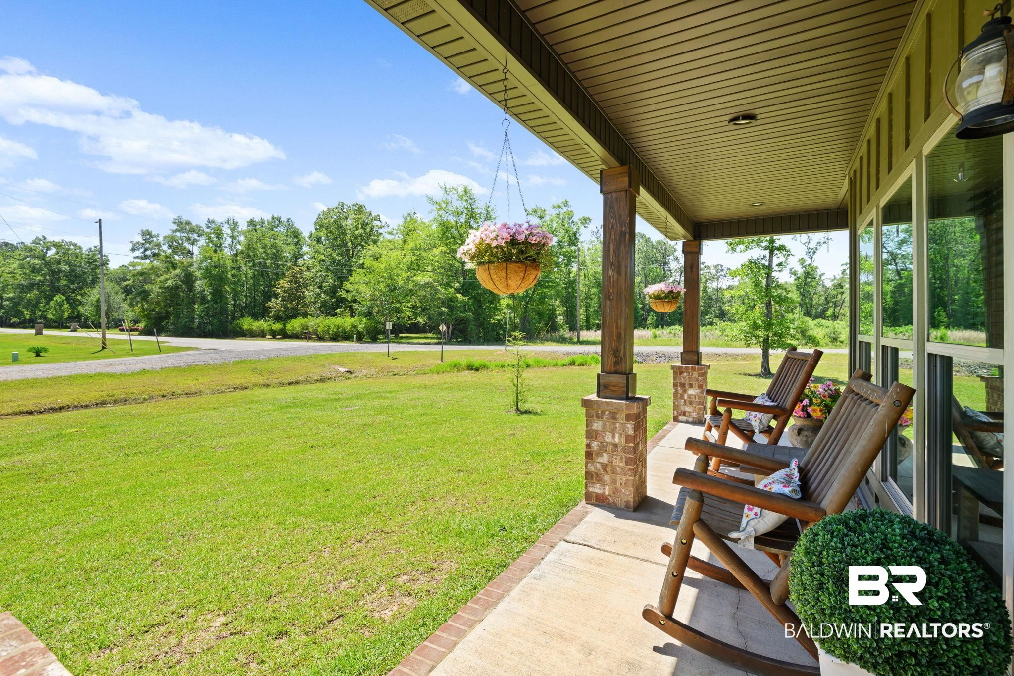 11025 Creax Road Axis, AL 36505 - Photo 5 of 45 Covered front porch featuring brick-base columns, wood-look siding, and large windows
