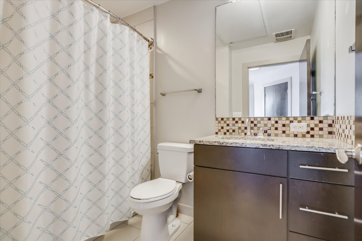 1320 Robert Browning Street, Unit 109 Austin, TX 78723 - Photo 6 of 16 a bathroom with a sink a toilet and shower curtain