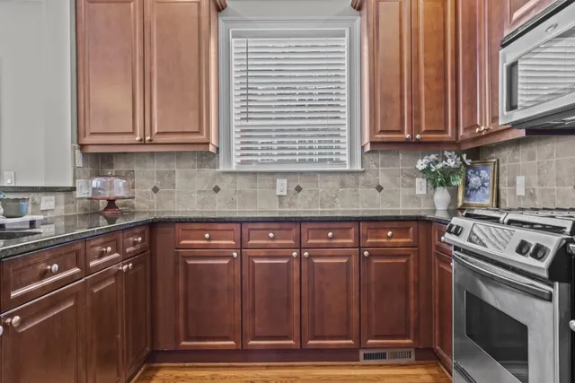 a kitchen with stainless steel appliances granite countertop a refrigerator a sink and a stove