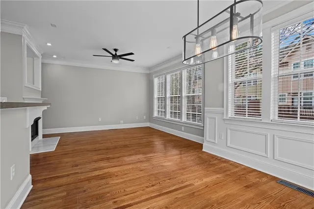 a kitchen with stainless steel appliances granite countertop a refrigerator a oven a sink and a wooden floor