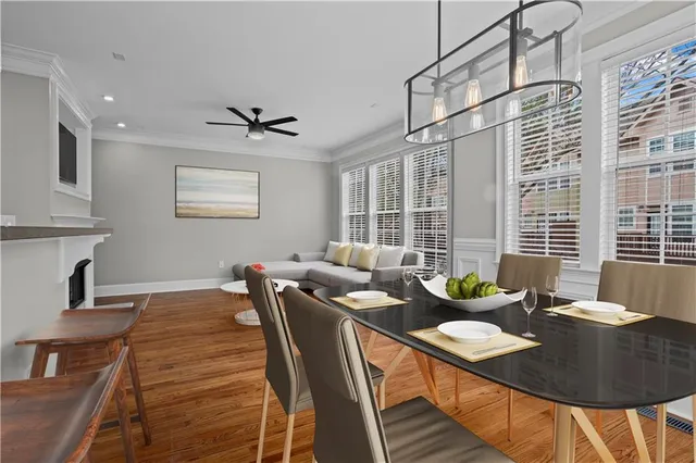 a large white kitchen with wooden floors and wide window