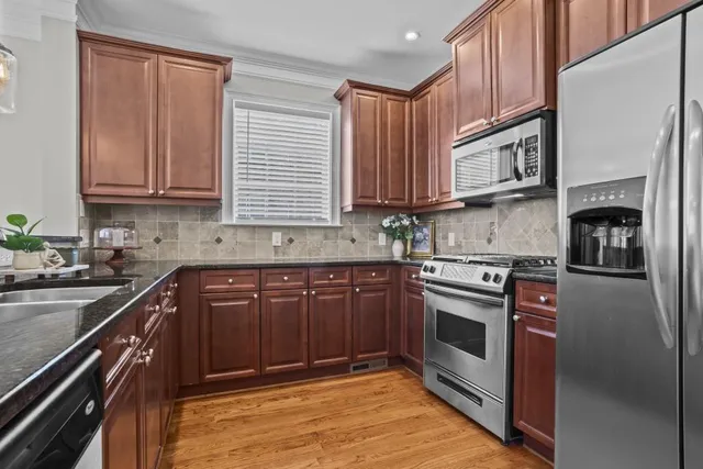 a kitchen with stainless steel appliances granite countertop a stove sink and cabinets