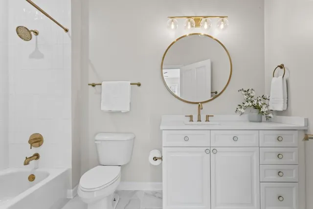 a bathroom with a toilet a sink and mirror