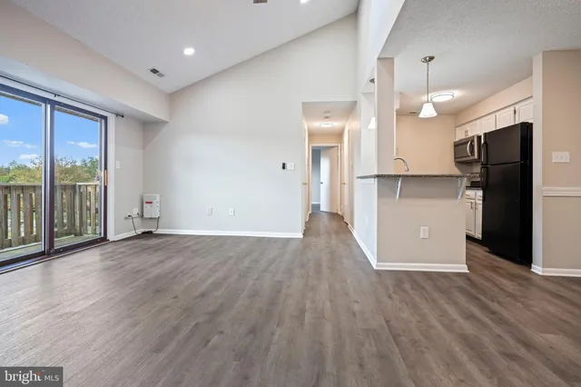 a view of a kitchen with wooden floor and a refrigerator