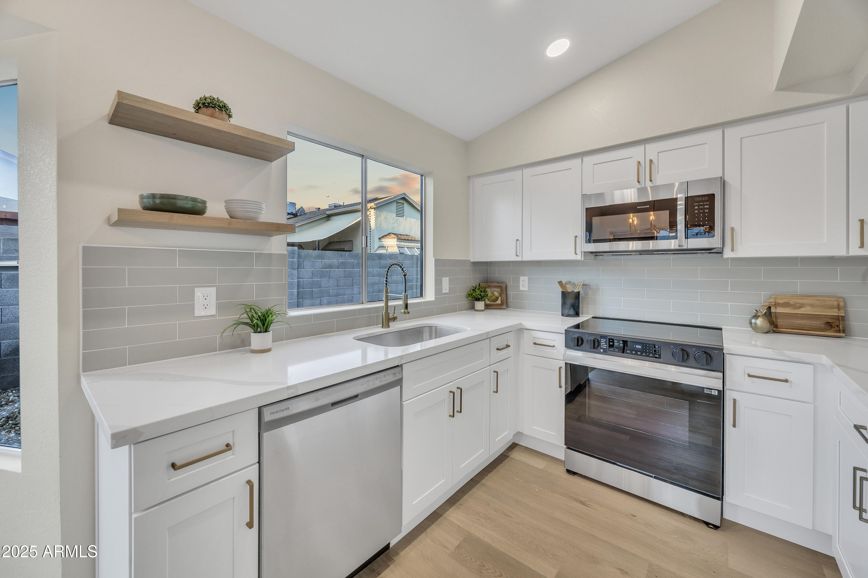 8830 West St John Road Peoria, AZ 85382 - Photo 10 of 25 a kitchen with stainless steel appliances granite countertop a sink and a stove