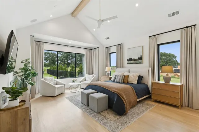 a bedroom with a bed couch and large window