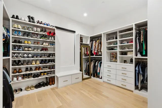 a view of walk in closet with clothes and shoes