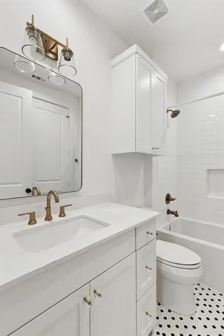 a bathroom with a sink a toilet and a mirror