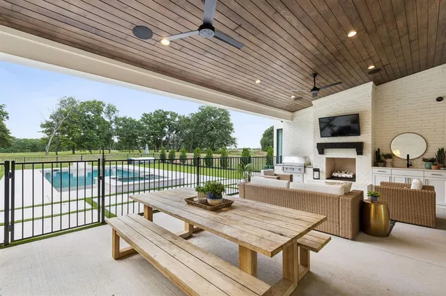 a view of a patio with a dining table chairs and a barbeque