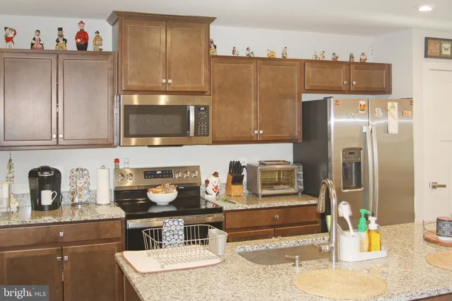 a kitchen with stainless steel appliances granite countertop a refrigerator and a stove