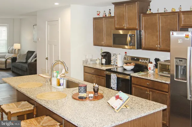 a kitchen with a dining table cabinets and living room view