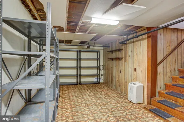 a view of an empty room with wooden floor and chair