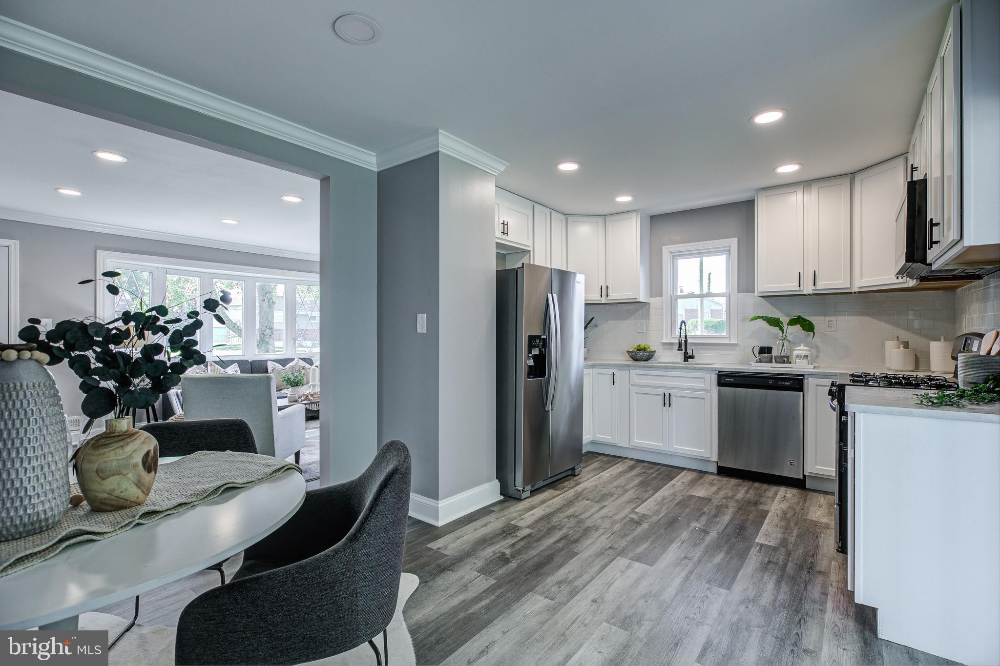 7410 Remoor Road Baltimore, MD 21207 - Photo 11 of 33 a kitchen with stainless steel appliances granite countertop a refrigerator a sink dishwasher a dining table and chairs with wooden floor